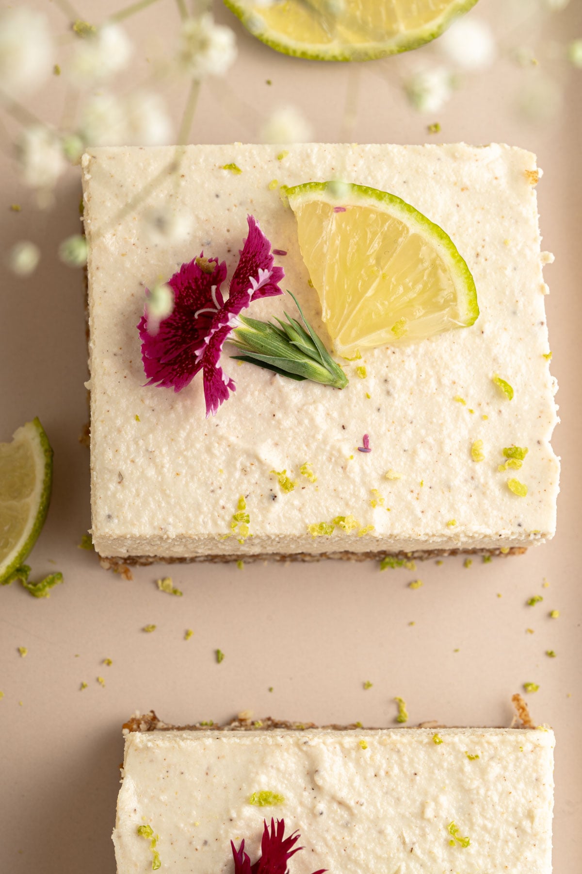 closeup overhead key lime dessert bars with flowers and lime garnish